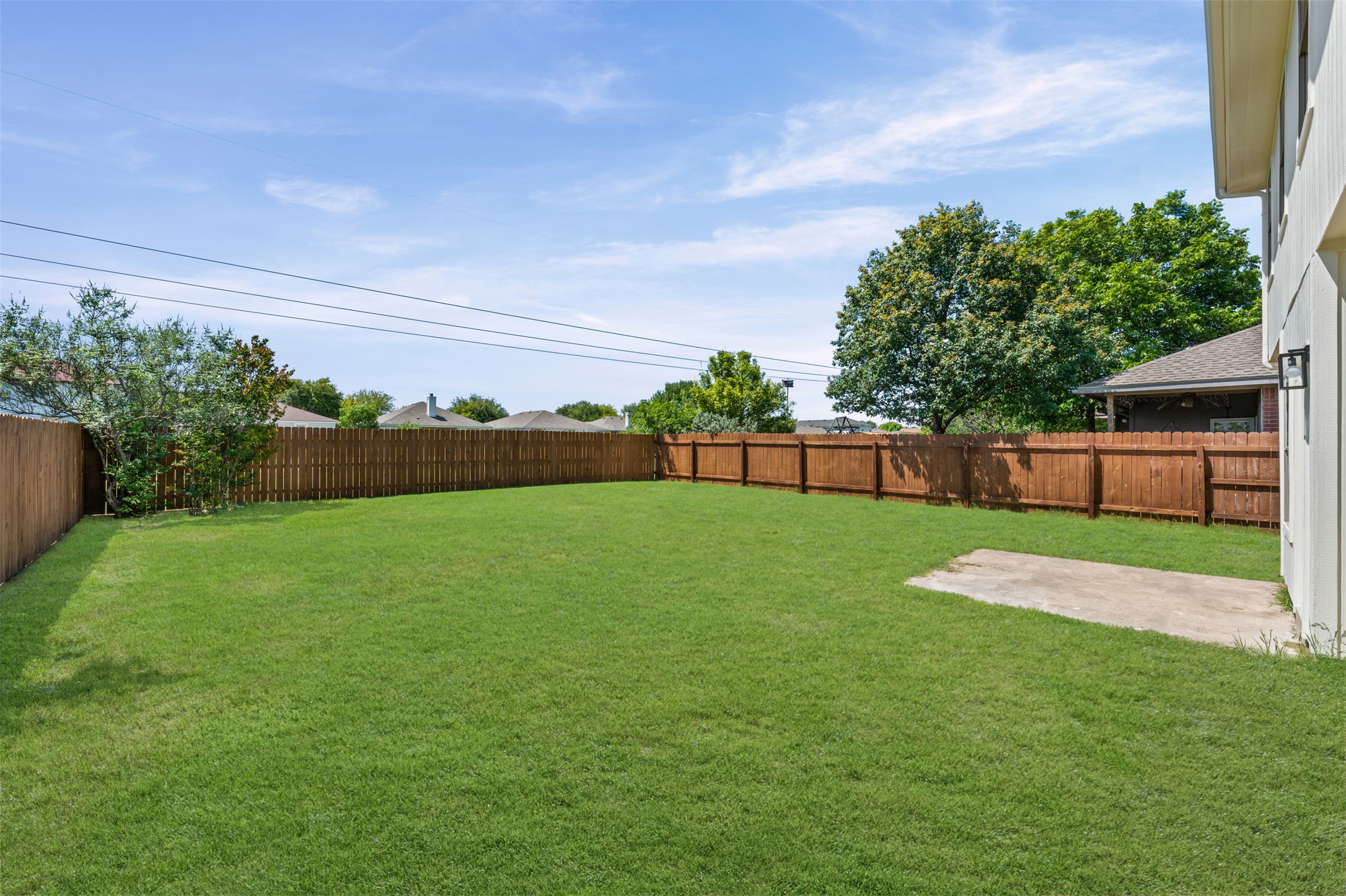 243 Engineers Pass Jarrell, TX 76537 - Photo 37 of 40 Spacious backyard featuring a manicured lawn, full privacy fencing, and a concrete patio pad