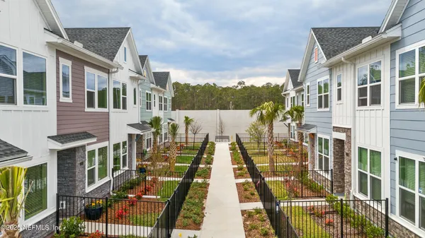 an aerial view of residential houses with outdoor space and lake view