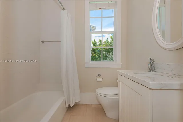a bedroom with a large bed a chandelier and windows