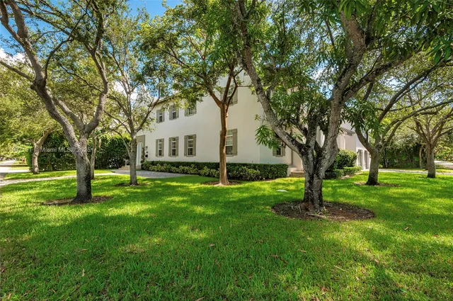 a front view of a house with a yard and trees
