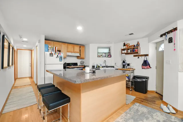 a view of kitchen with refrigerator stove and wooden floor