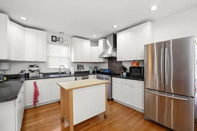 a kitchen with a refrigerator a stove top oven a sink and cabinets