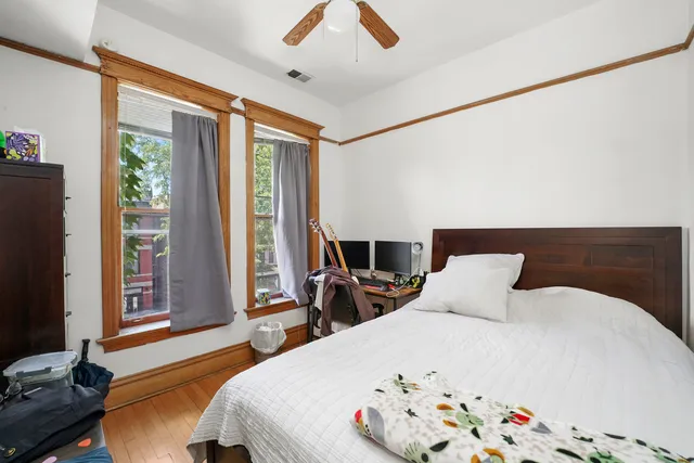 a bedroom with a bed and a flat tv screen next to a window