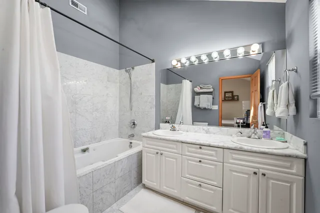 a bathroom with a sink double vanity granite tub and shower
