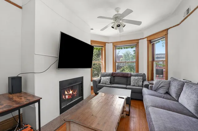 a living room with furniture a flat screen tv and a fireplace