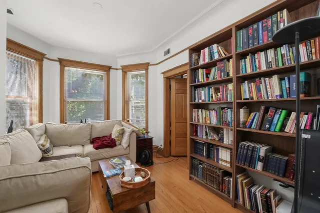 a living room with a book shelf and a window