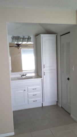 2500 Fiore Way, Unit 1110 Delray Beach, FL 33445 - Photo 7 of 12 a bathroom with a granite countertop sink and a mirror