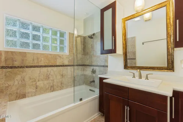 a bathroom with a bathtub sink and mirror