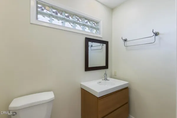 a bathroom with a toilet a sink and mirror