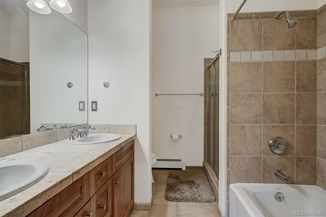 a bathroom with a granite countertop sink a toilet and shower