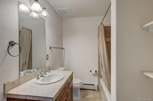 a bathroom with a granite countertop sink toilet and a mirror
