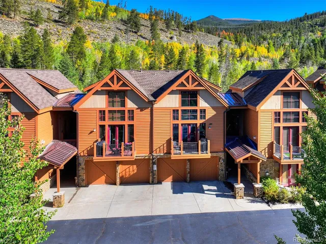 a view of a house with a big yard plants and large trees
