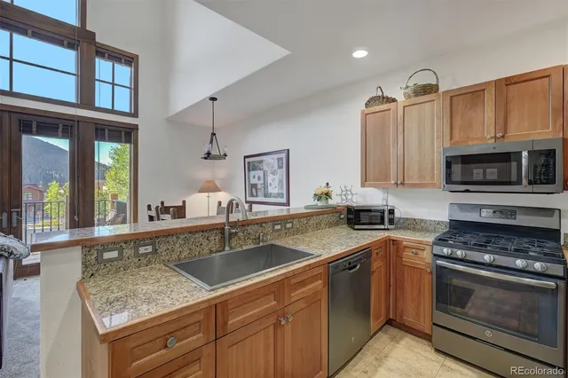 a kitchen with stainless steel appliances granite countertop a sink stove and microwave