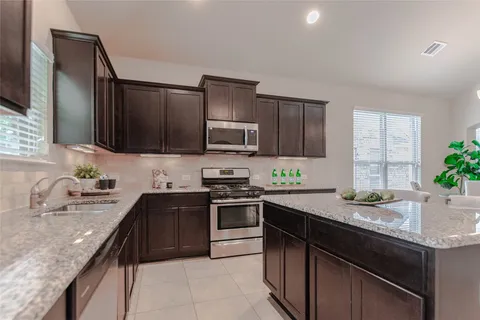 a kitchen with granite countertop stainless steel appliances and sink