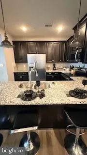 a view of kitchen with stainless steel appliances kitchen island sink stove and refrigerator