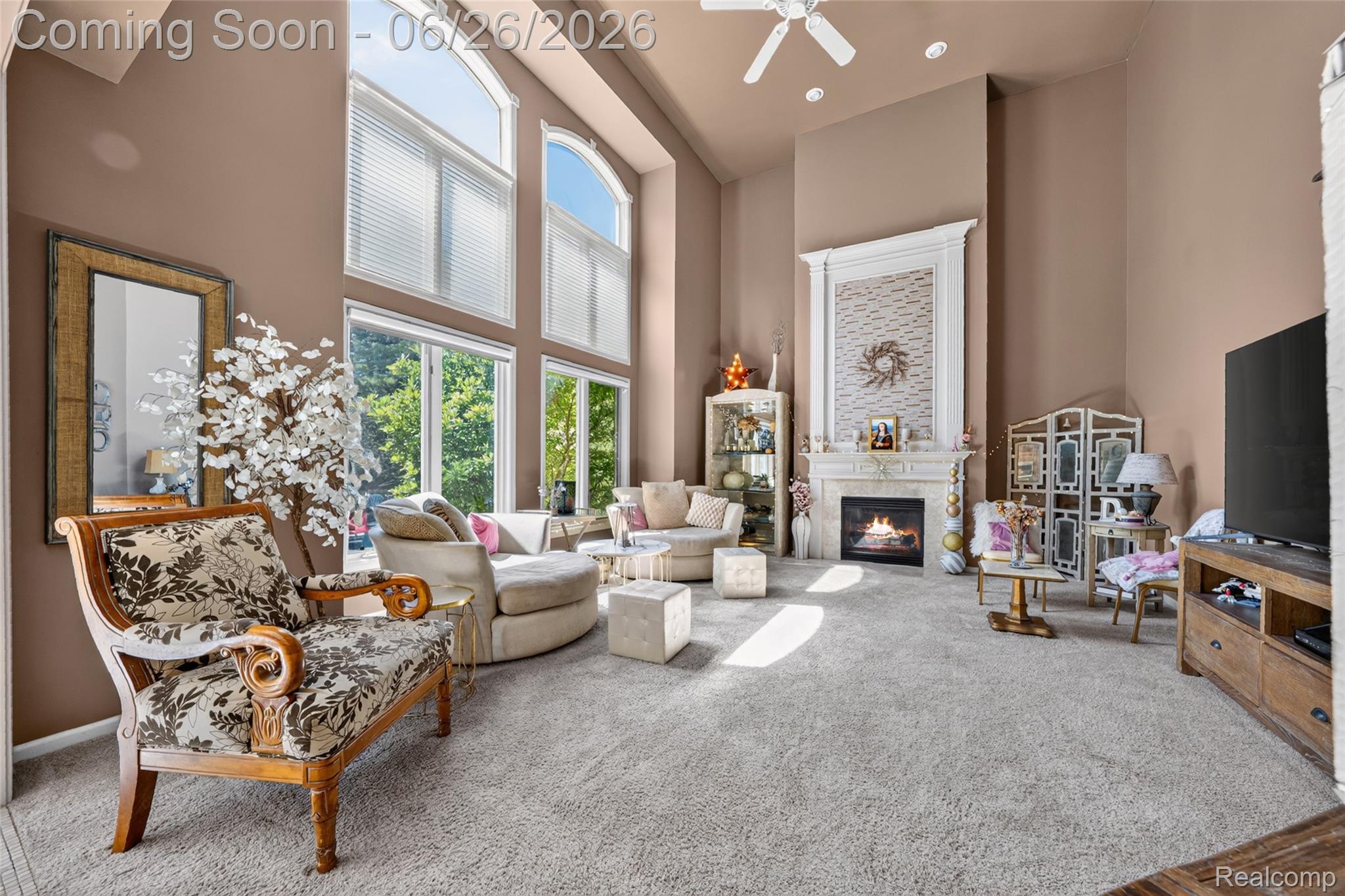 2619 Lambeth Park Rochester, MI 48306 - Photo 28 of 71 Two-story living area featuring a fireplace with decorative mantel, floor-to-ceiling windows, and a ceiling fan