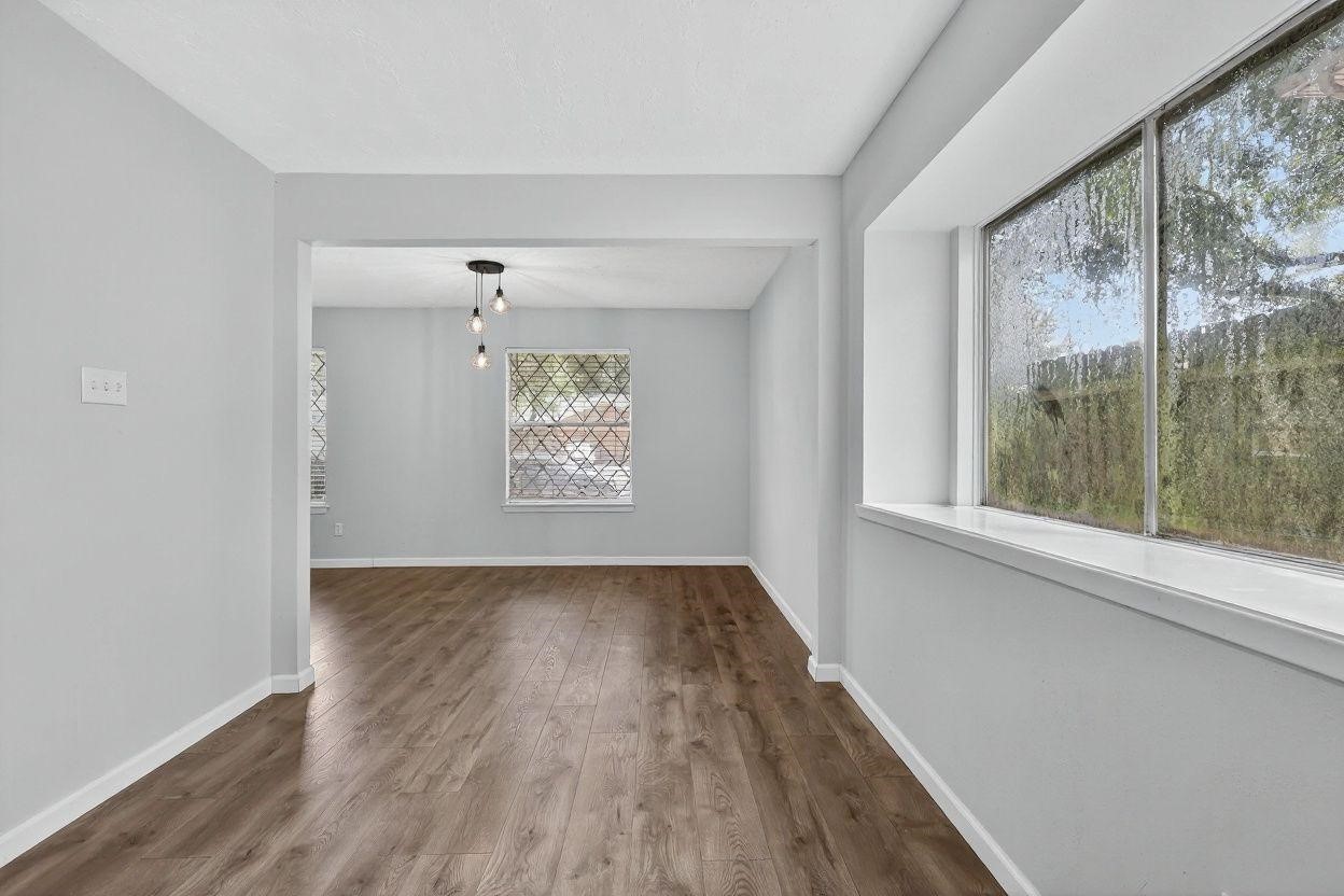7331 Misty Morning Drive Humble, TX 77346 - Photo 9 of 19 a view of an empty room with wooden floor and a window