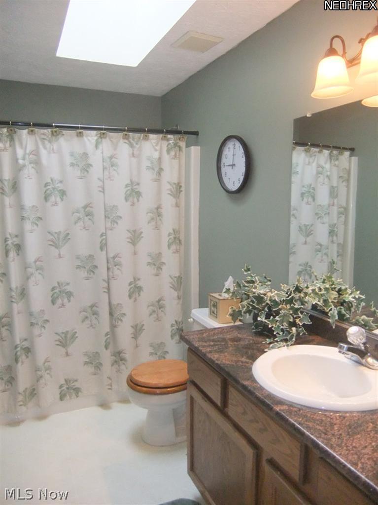 3795 Stonebridge Boulevard Akron, OH 44321 - Photo 19 of 24 The next room in the hallway is the main bathroom with a skylight and white tub surround.