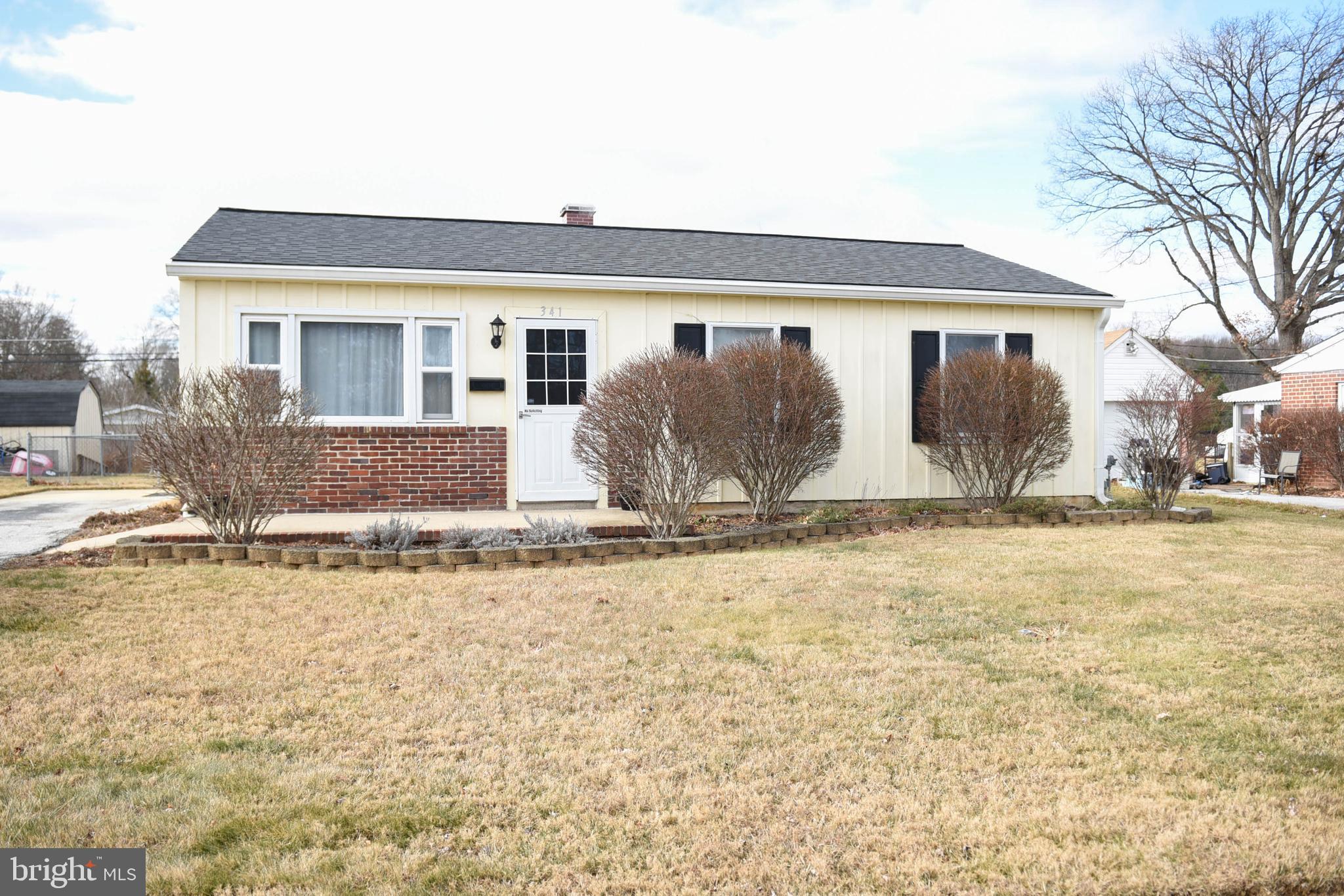 a front view of house with yard covered in snow