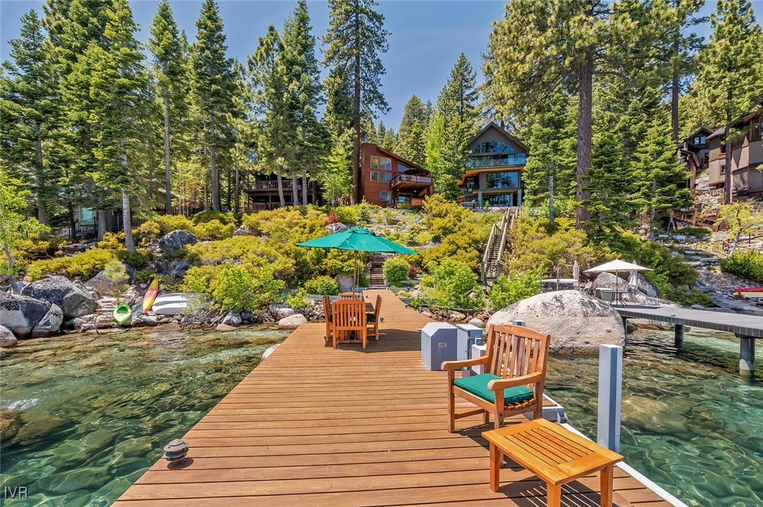 a view of a wooden deck and chairs next to a yard