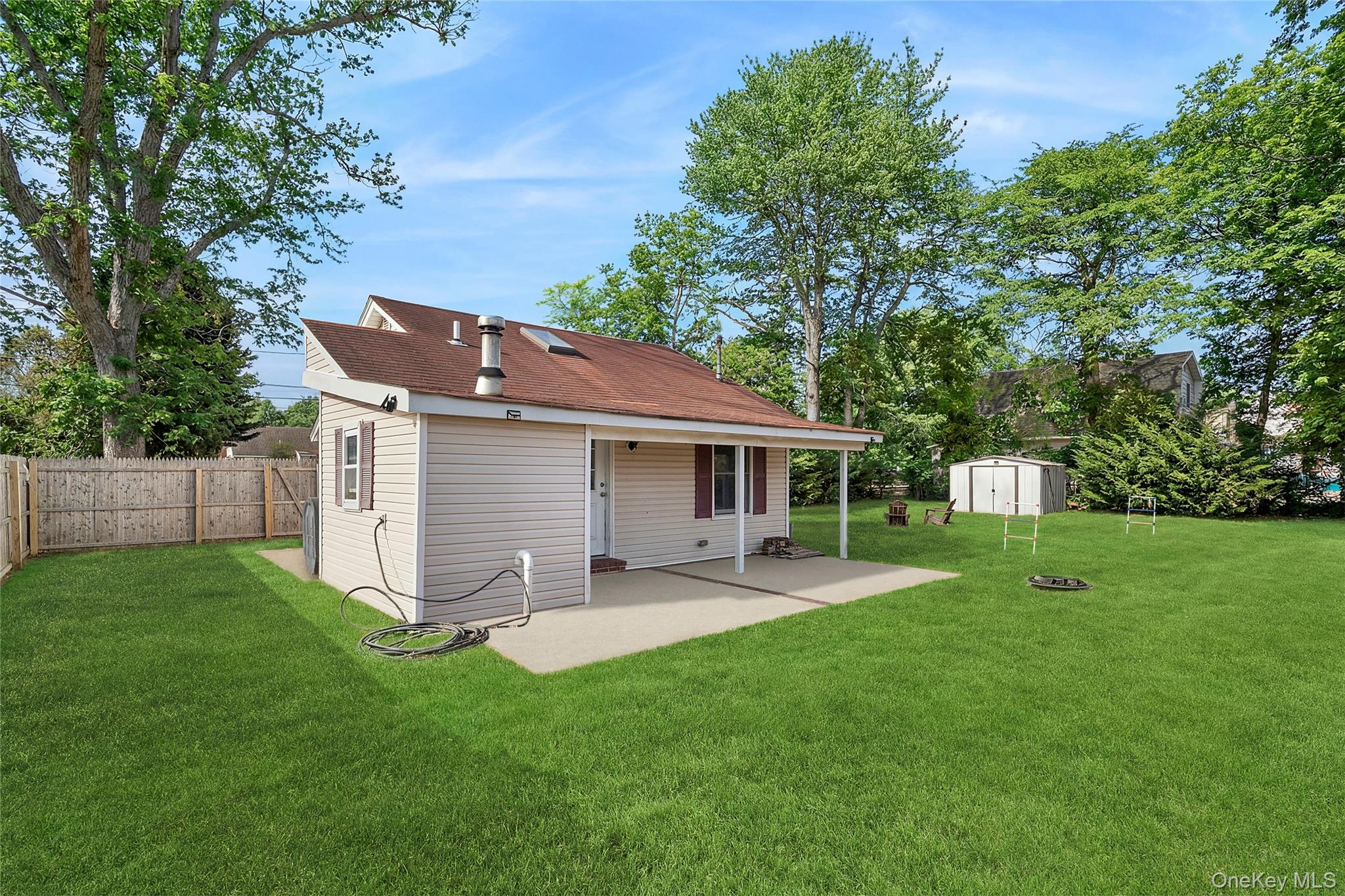 69 Locust Drive Mastic Beach, NY 11951 - Photo 11 of 13 a front view of house with a garden and trees