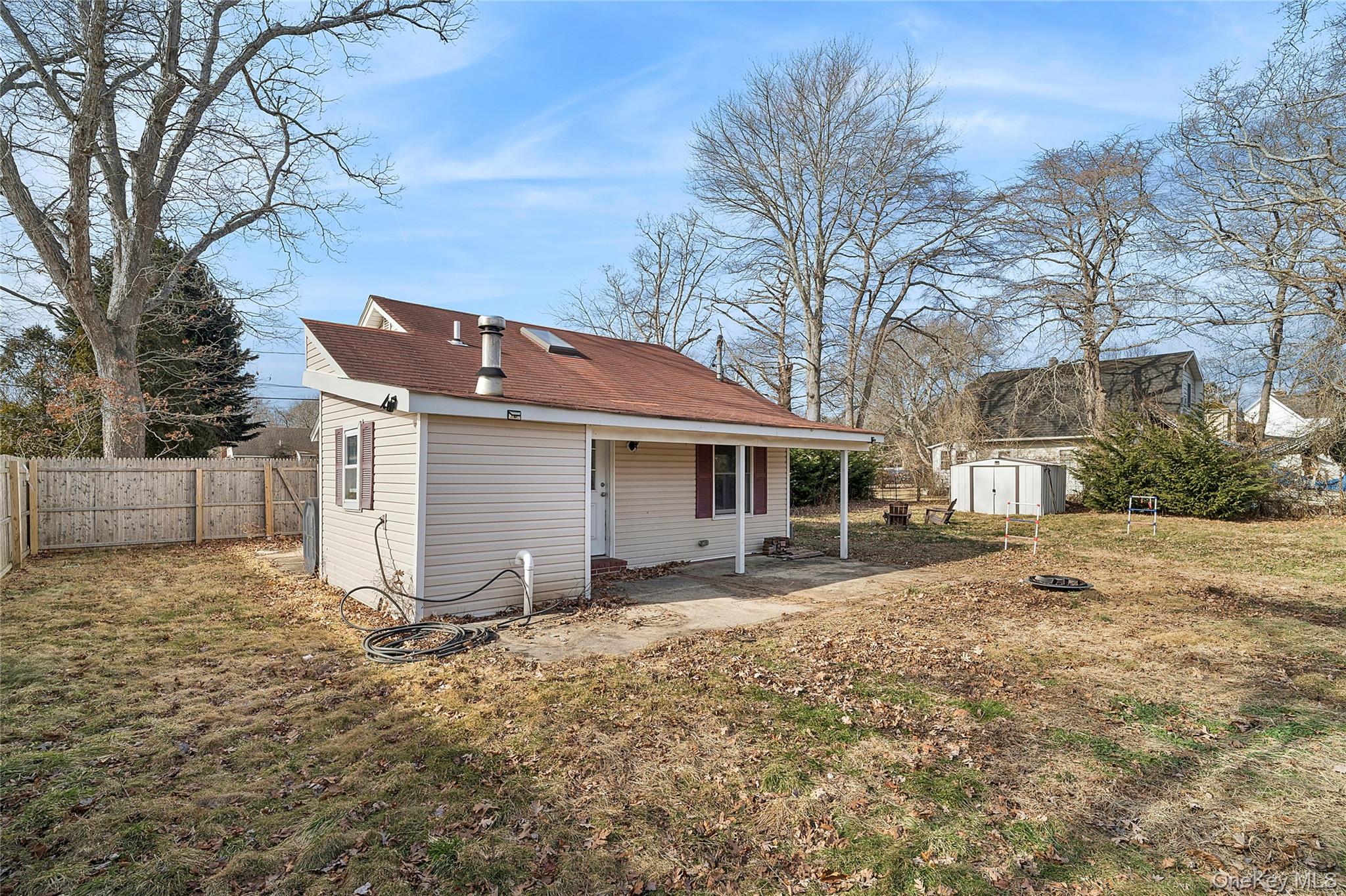 69 Locust Drive Mastic Beach, NY 11951 - Photo 12 of 13 a front view of house with yard and trees in the background