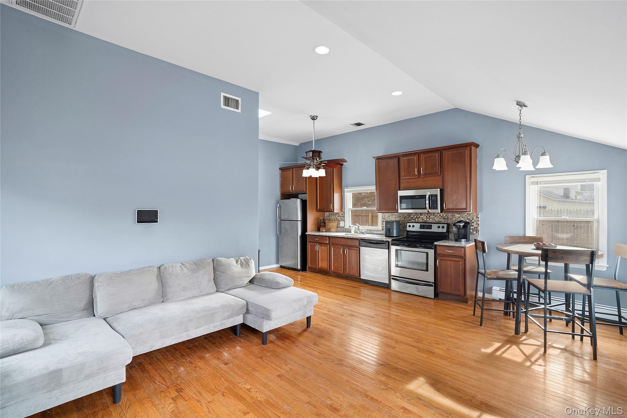 69 Locust Drive Mastic Beach, NY 11951 - Photo 3 of 13 a living room with furniture kitchen view and a wooden floor