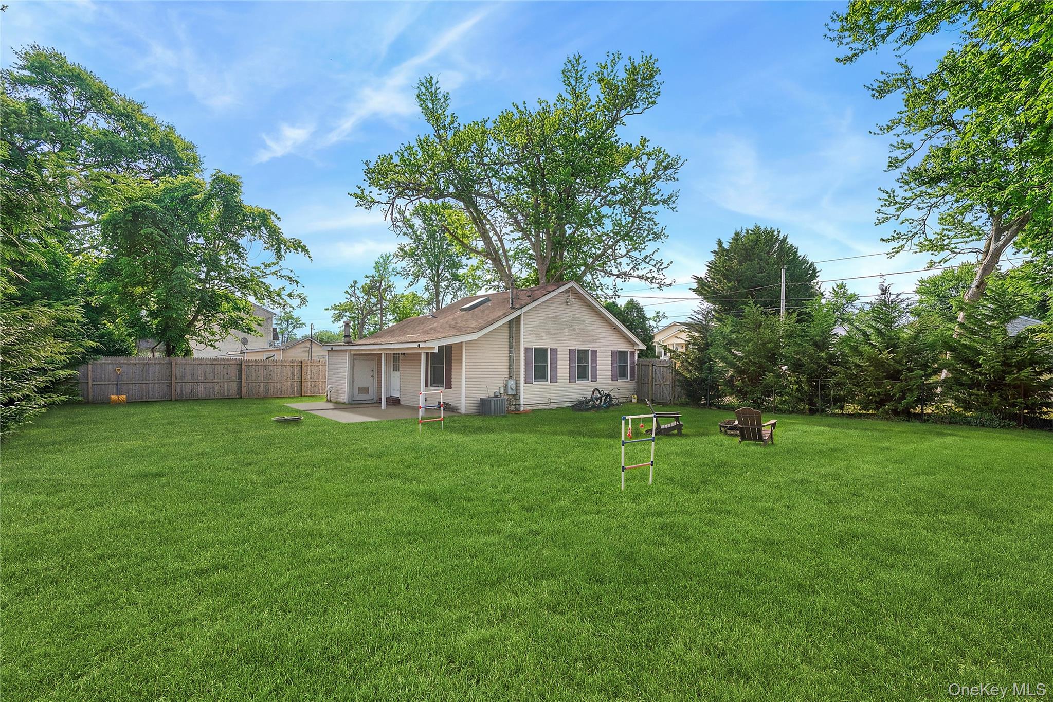 69 Locust Drive Mastic Beach, NY 11951 - Photo 9 of 13 a white house with a big yard and large trees