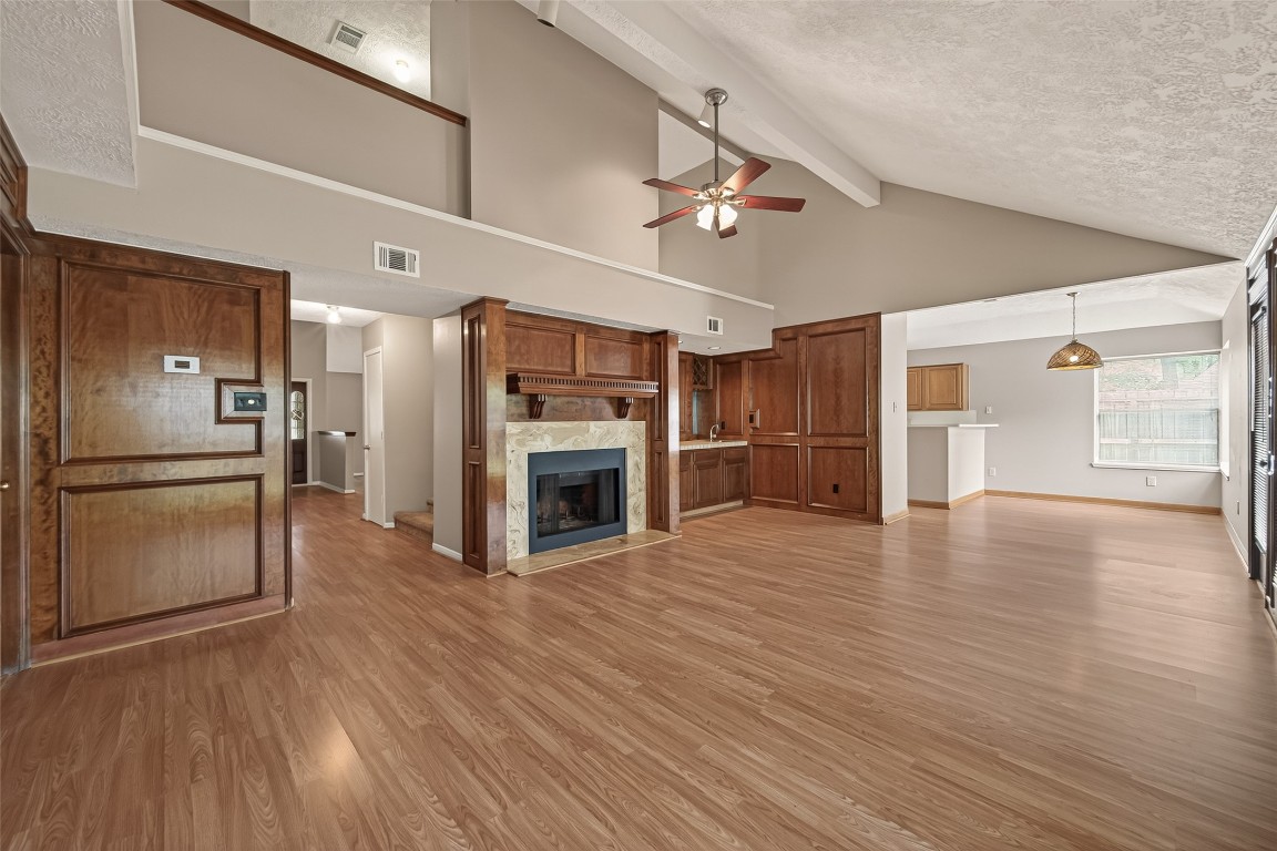 5003 Dawn Lily Drive Spring, TX 77388 - Photo 15 of 49 a view of a kitchen with a refrigerator a stove top oven hallway wooden floor and a living room