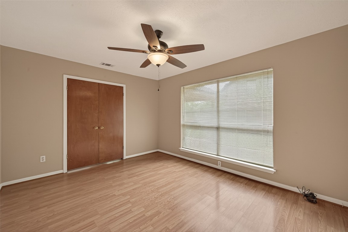 5003 Dawn Lily Drive Spring, TX 77388 - Photo 25 of 49 an empty room with wooden floor fan and windows