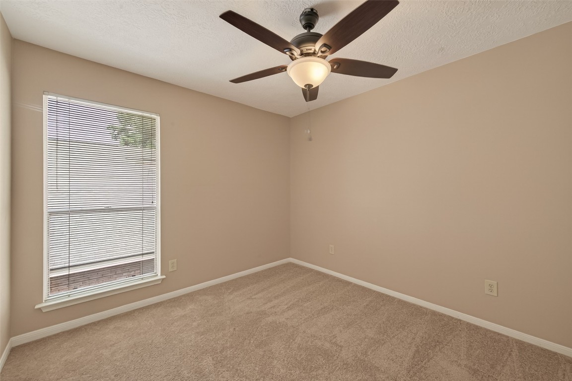 5003 Dawn Lily Drive Spring, TX 77388 - Photo 43 of 49 an empty room with a chandelier fan and windows