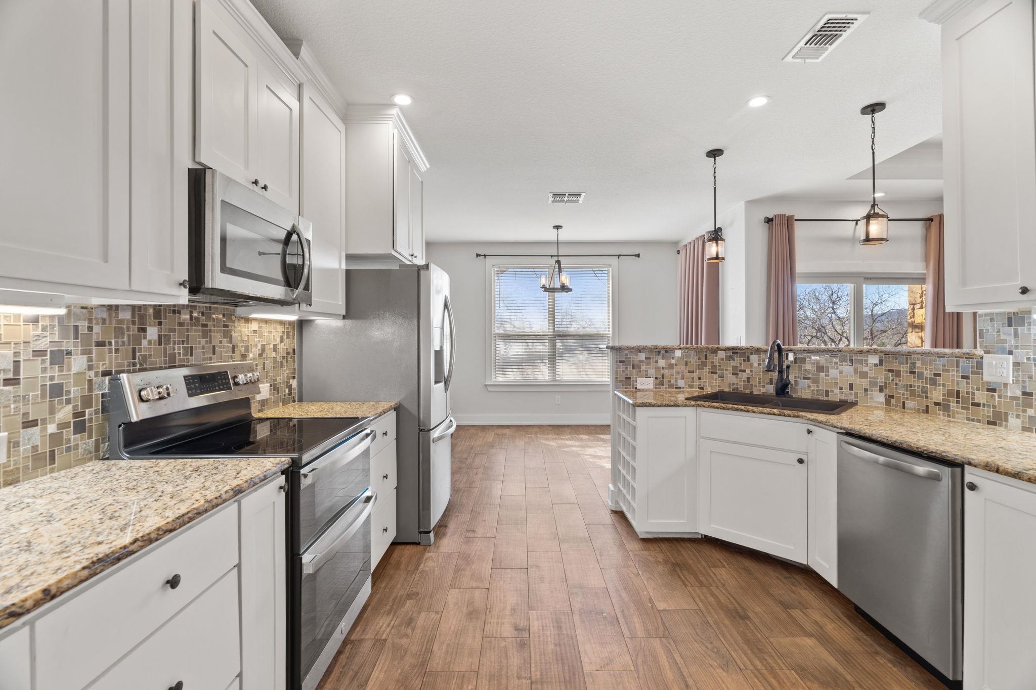 110 Chaumont Street Kingsland, TX 78639 - Photo 11 of 29 a kitchen with stainless steel appliances granite countertop wooden cabinets a sink a stove a refrigerator and island