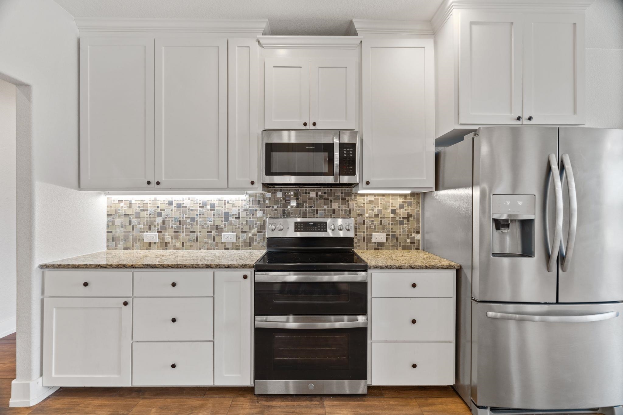 110 Chaumont Street Kingsland, TX 78639 - Photo 12 of 29 a kitchen with granite countertop white cabinets and stainless steel appliances