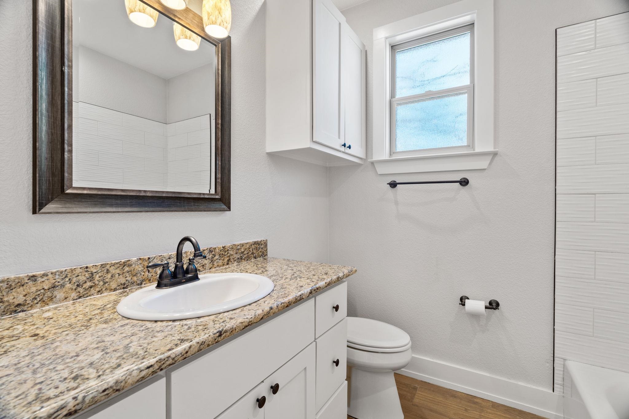 110 Chaumont Street Kingsland, TX 78639 - Photo 23 of 29 a bathroom with a granite countertop sink a toilet and a mirror