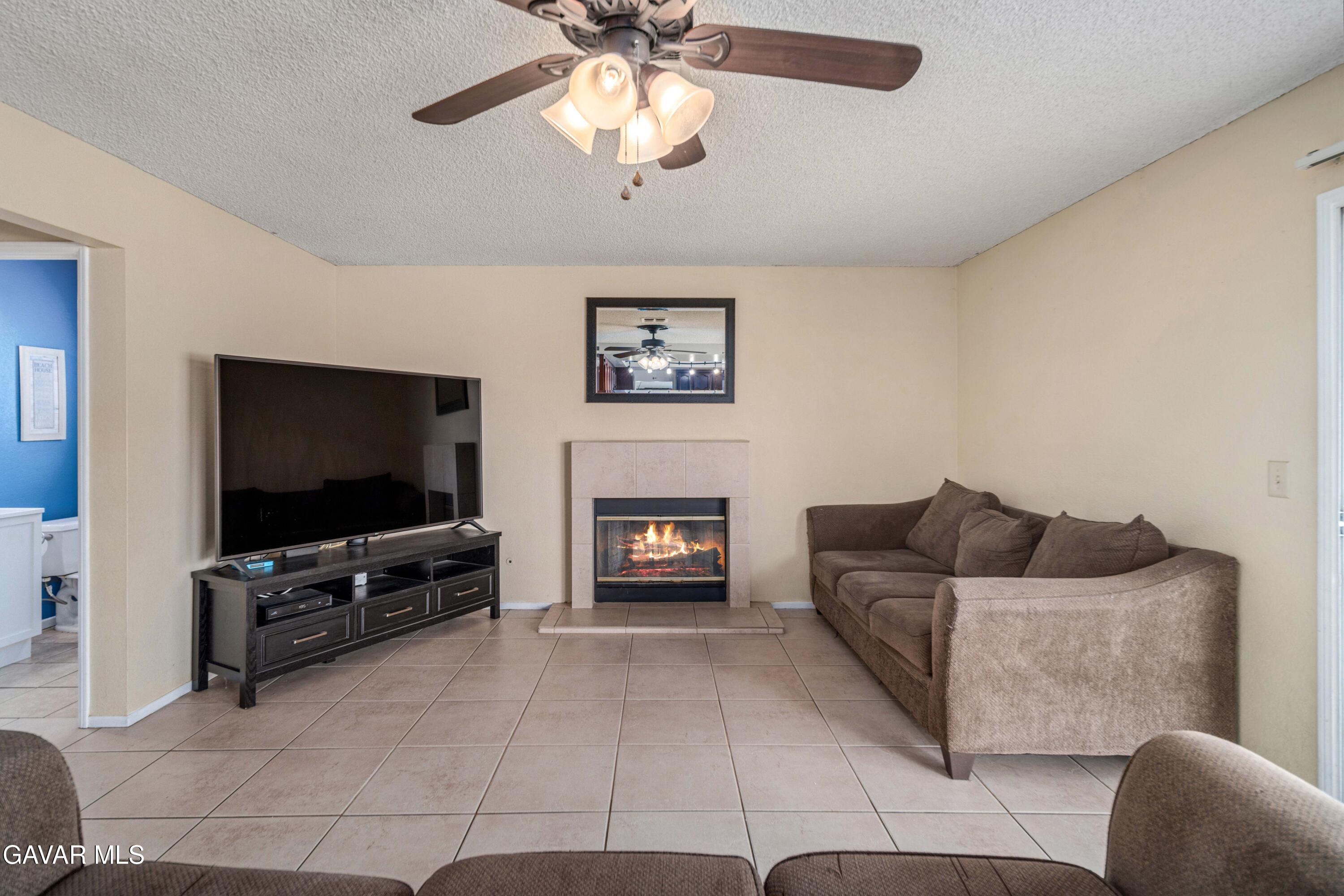 1605 Bluebell Street Lancaster, CA 93535 - Photo 15 of 40 a living room with furniture a flat screen tv and a fireplace