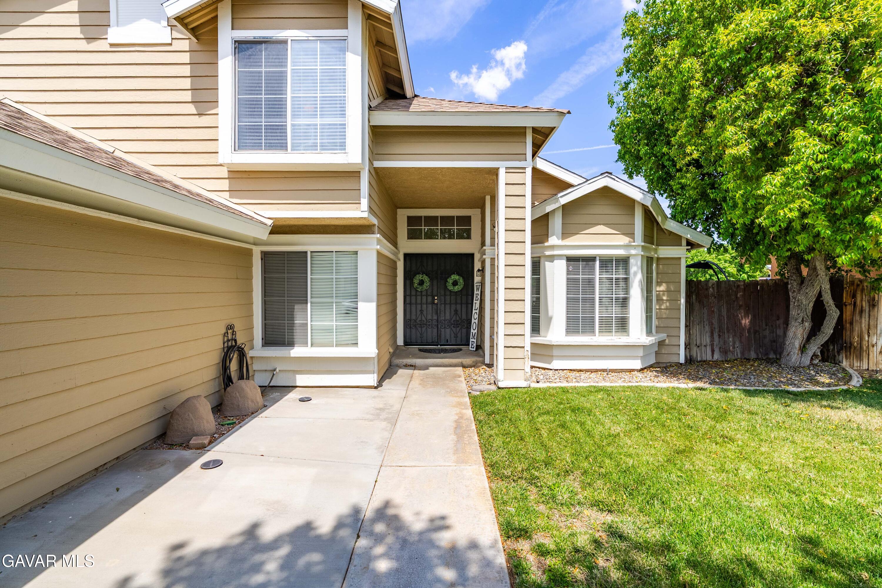 1605 Bluebell Street Lancaster, CA 93535 - Photo 6 of 40 a front view of a house with a yard and garage