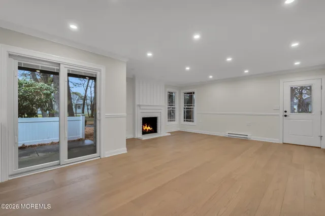 a view of an empty room with a fireplace and a window