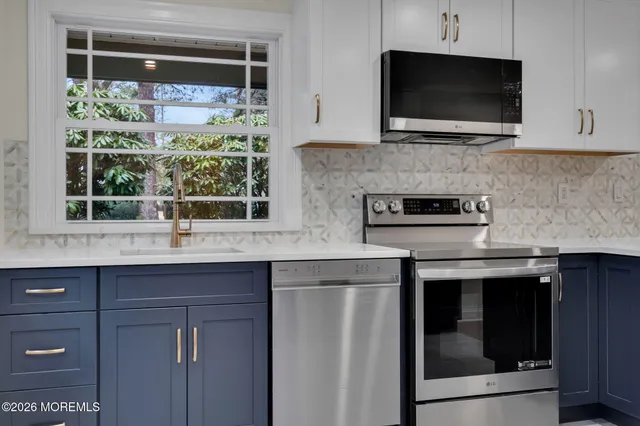 a kitchen with stainless steel appliances granite countertop a sink and a microwave