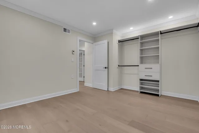 a view of walk in closet with empty racks