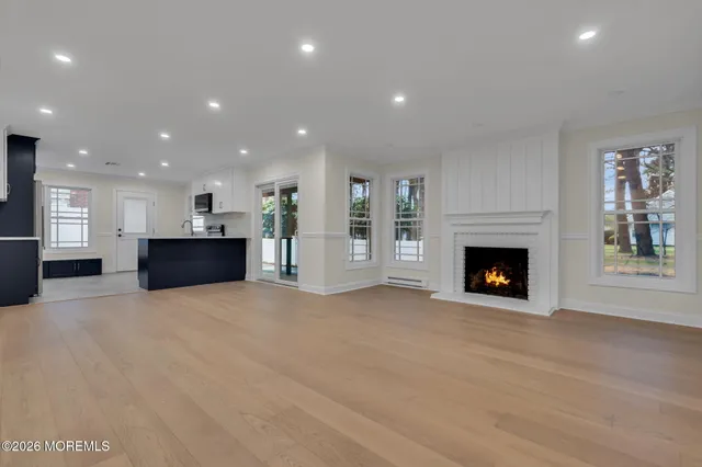 a view of an empty room with a fireplace and window