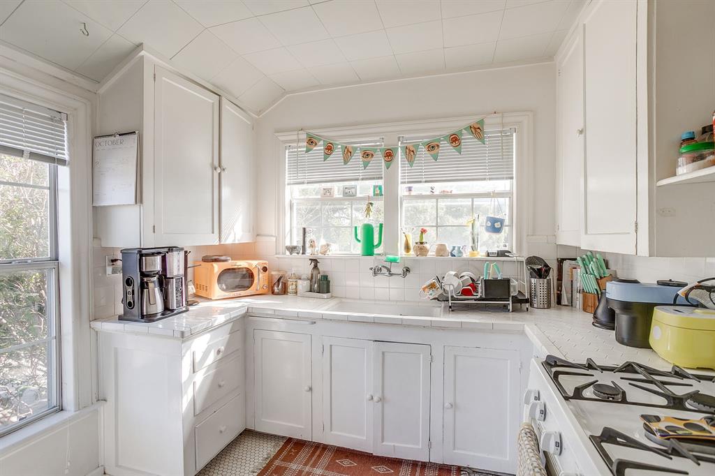 4339 Pershing Avenue Fort Worth, TX 76107 - Photo 11 of 19 a kitchen with sink a stove and white cabinets