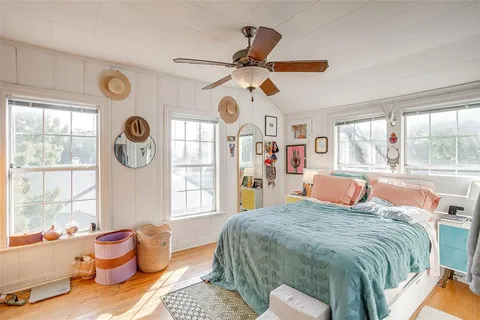 a bedroom with a bed dresser and window