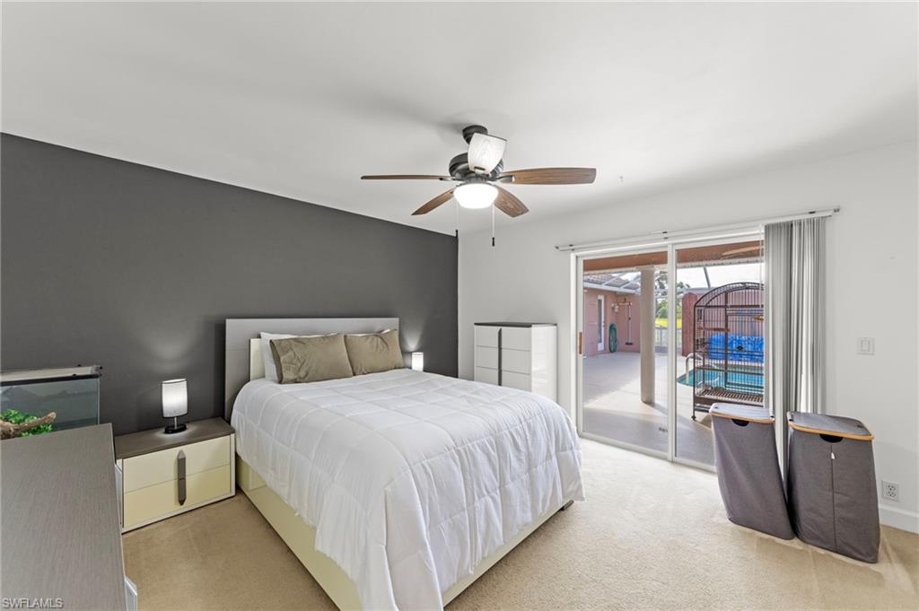 13541 Stringfellow Road Bokeelia, FL 33922 - Photo 22 of 49 a bedroom with a large bed and a chandelier