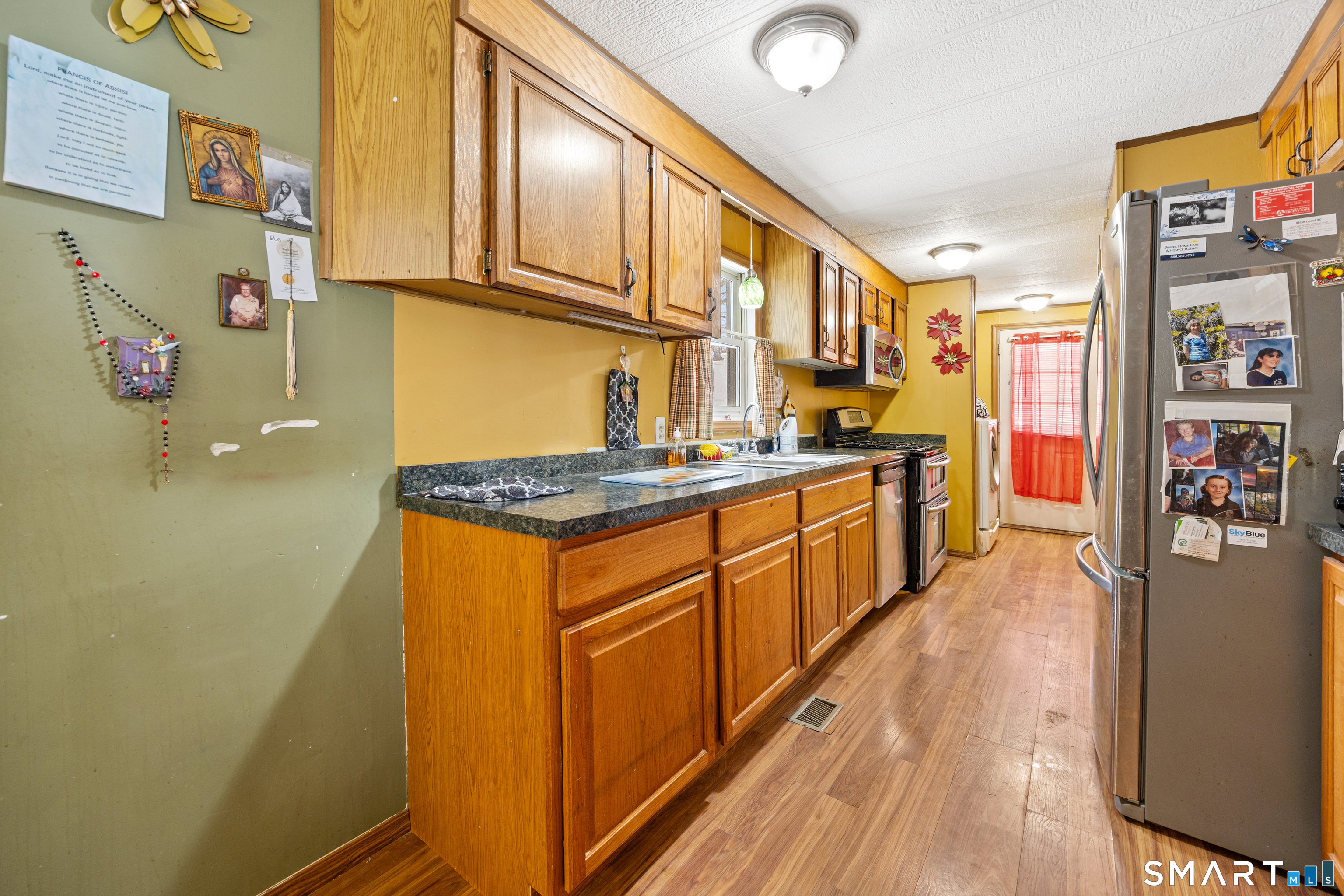 8 Redstone Street Southington, CT 06489 - Photo 4 of 18 a kitchen with stainless steel appliances granite countertop a refrigerator a stove and a wooden floor