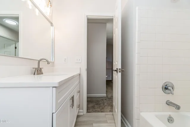 a bathroom with a sink a vanity and a tub