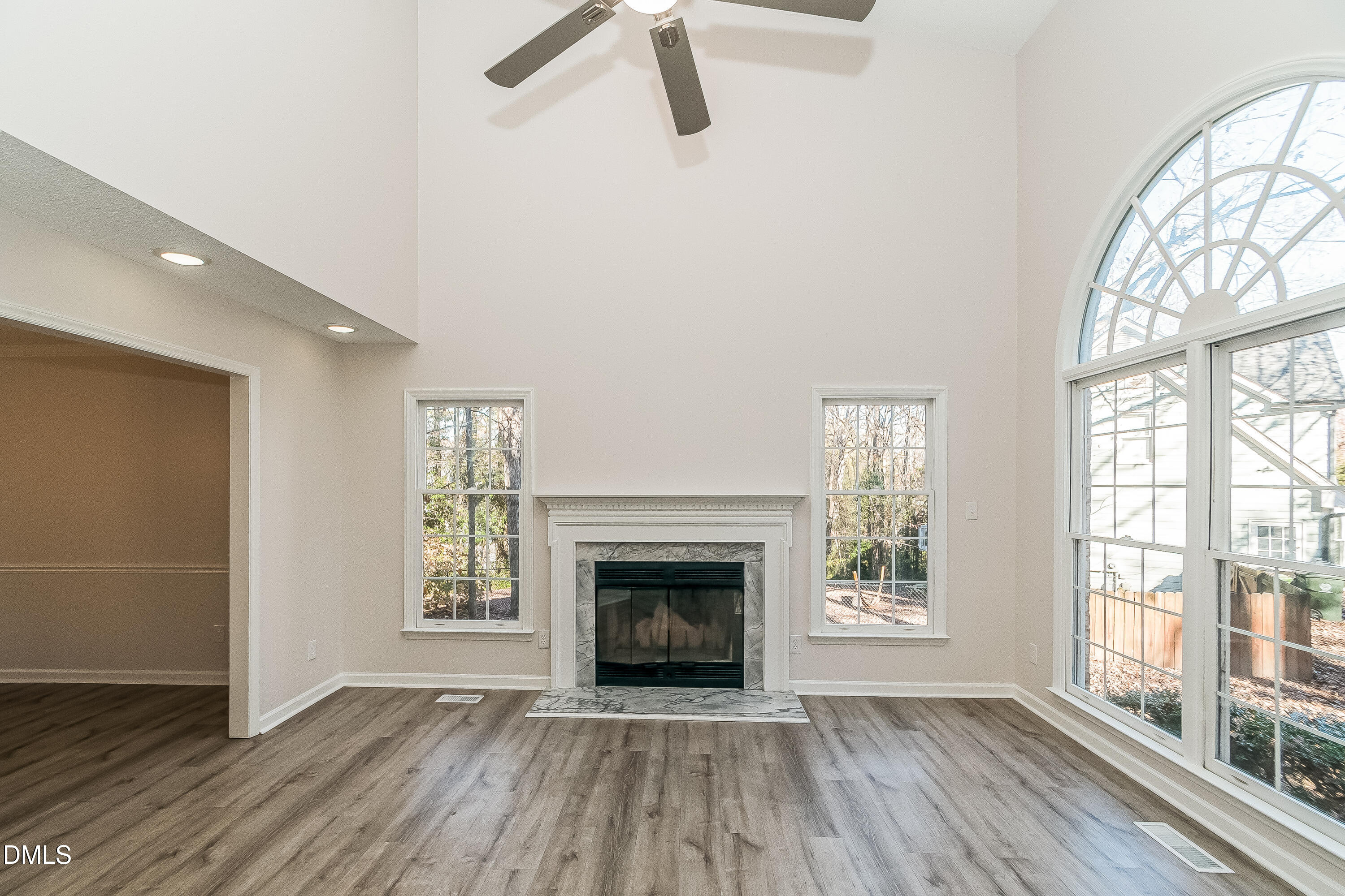 6005 Chittim Court Raleigh, NC 27616 - Photo 3 of 19 an empty room with wooden floor fireplace and windows