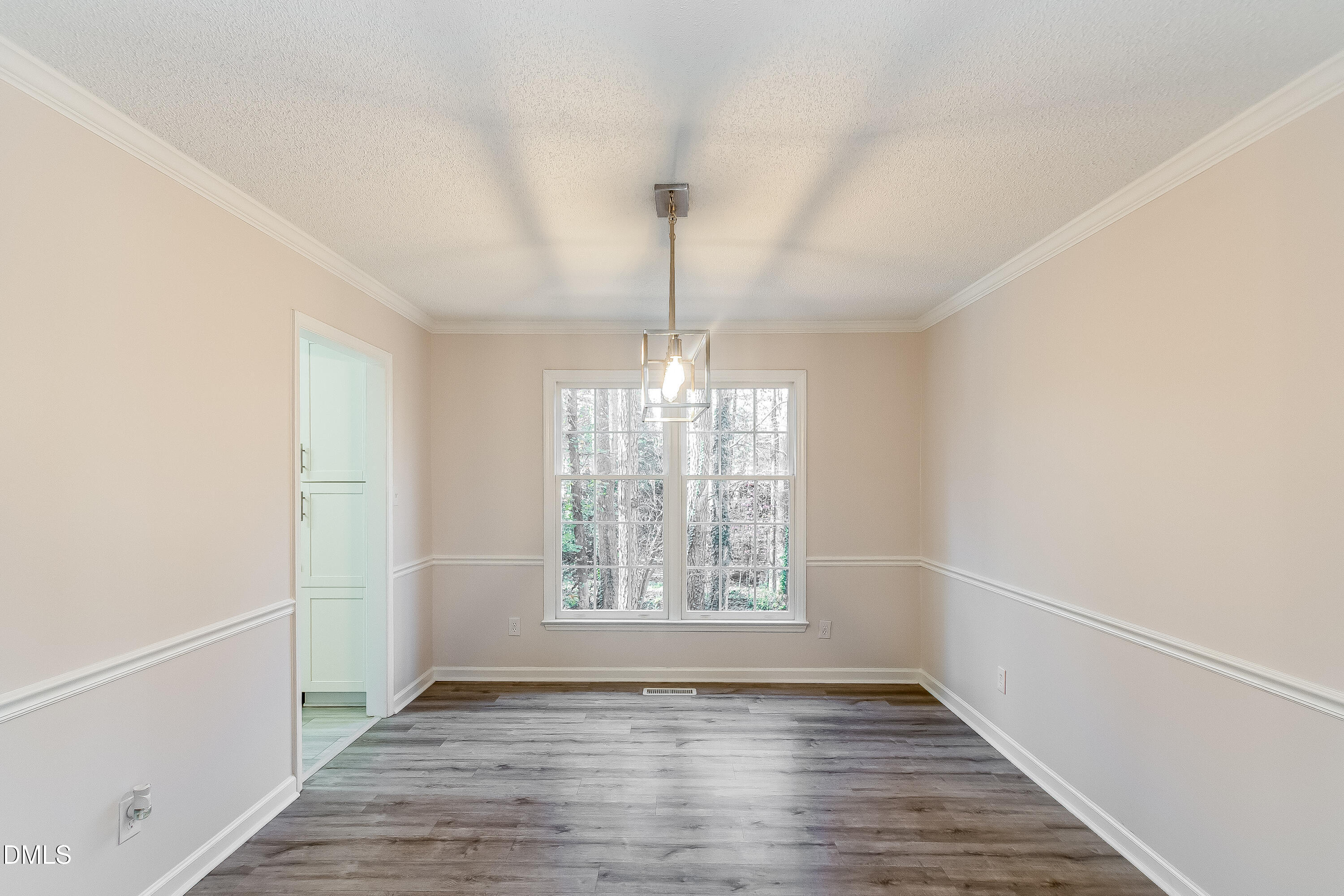 6005 Chittim Court Raleigh, NC 27616 - Photo 4 of 19 a view of an empty room with wooden floor and a window