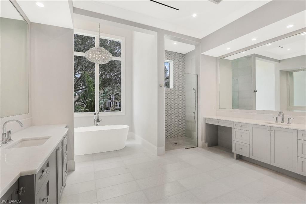313 Turtle Hatch Road Naples, FL 34103 - Photo 12 of 34 a bathroom with a tub sink shower and mirror