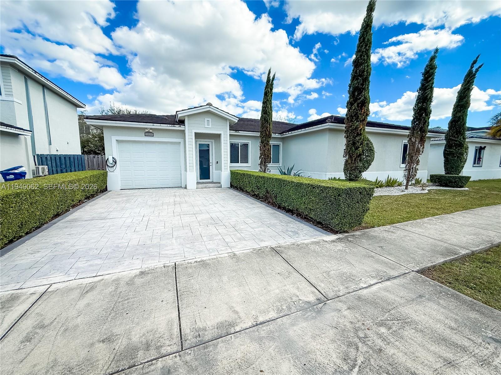 17931 Southwest 152nd Avenue Miami, FL 33187 - Photo 2 of 29 a front view of a house with a garden and garage