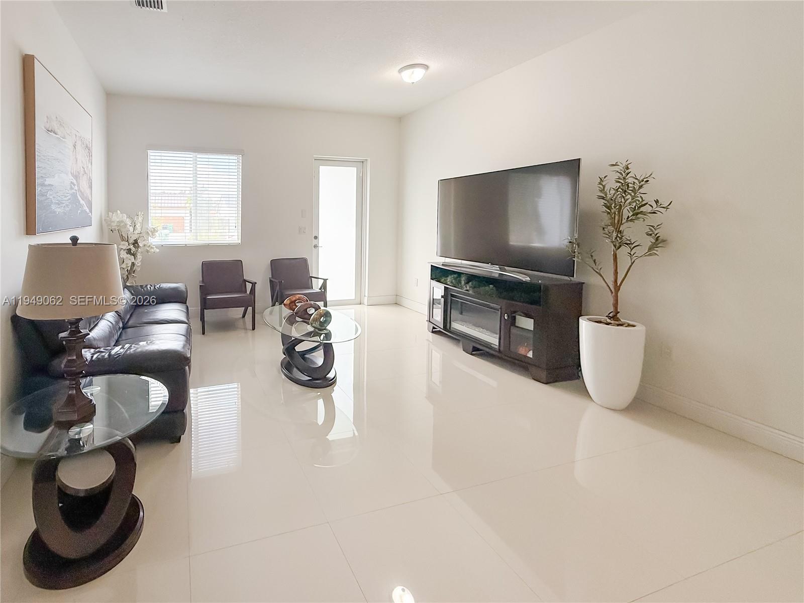 17931 Southwest 152nd Avenue Miami, FL 33187 - Photo 4 of 29 a living room with furniture and a flat screen tv